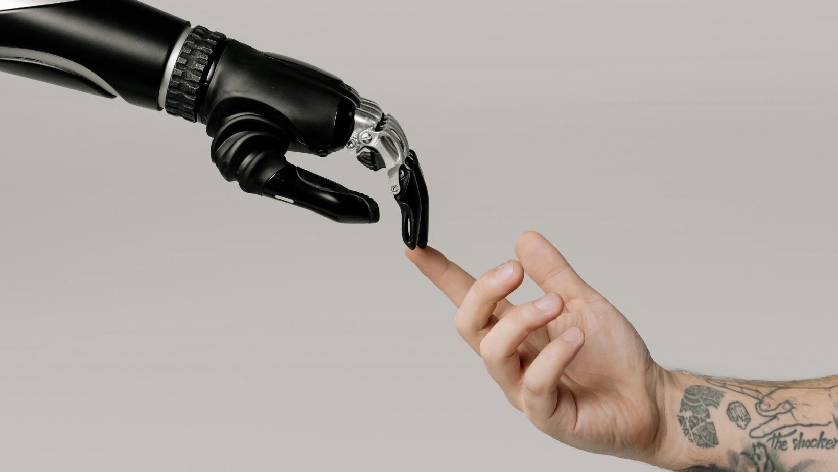 A human hand touches a robot hand.