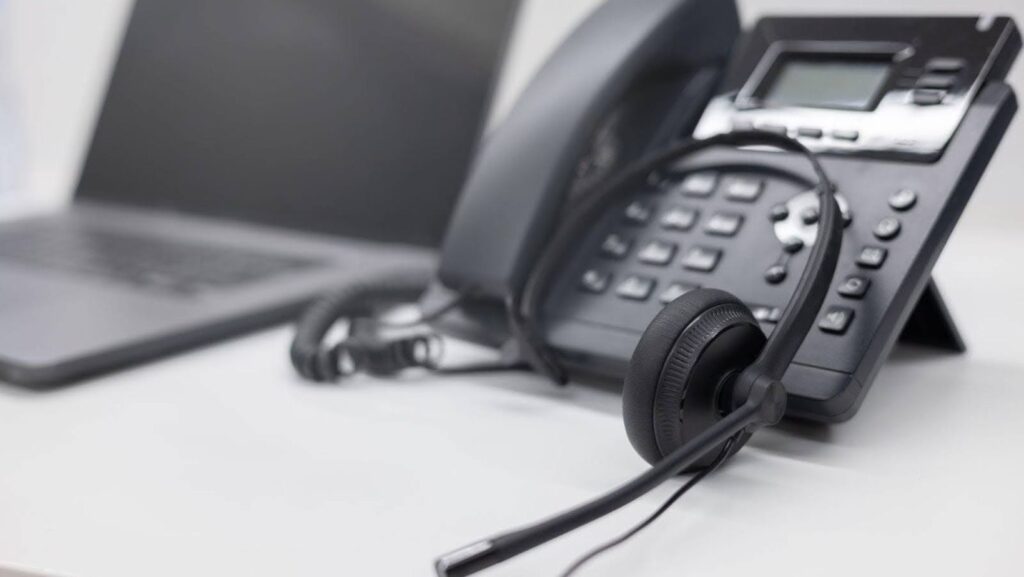 phone and headset next to laptop