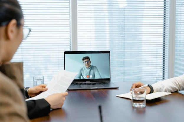 Two people in an office having an online meeting with their partner